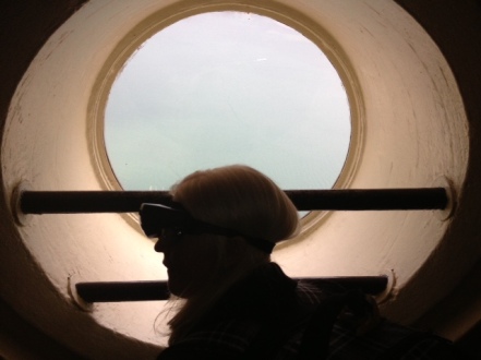 A  picture of me silhouetted  in front of a circular window with my large electronic glasses on